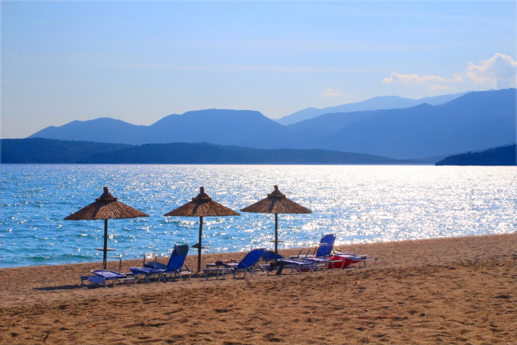 Parasols at the beach in front of the Peloponnesian mountains