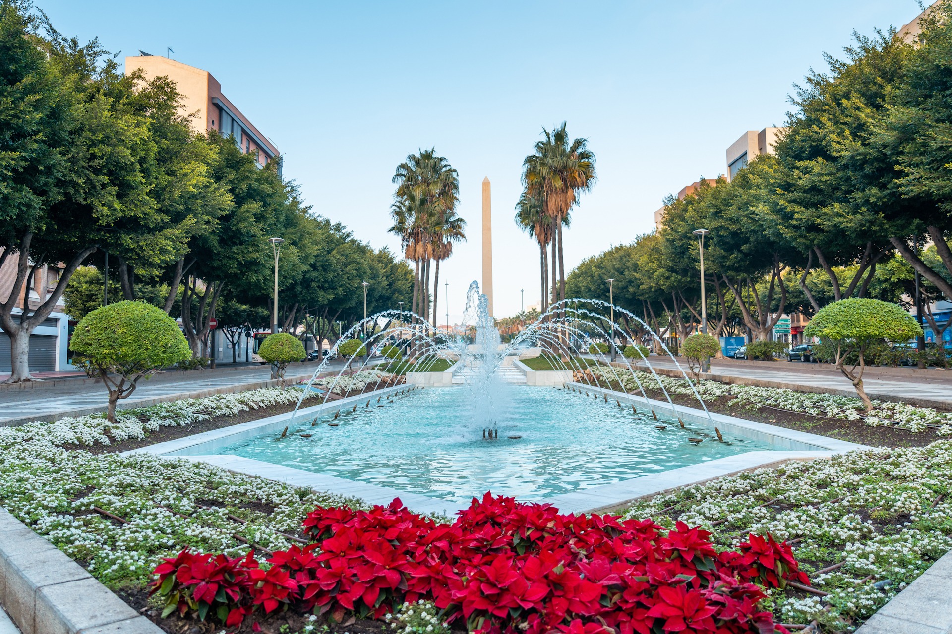 Water fountain and flowers next to the palm trees in the Belen Costa Almeria