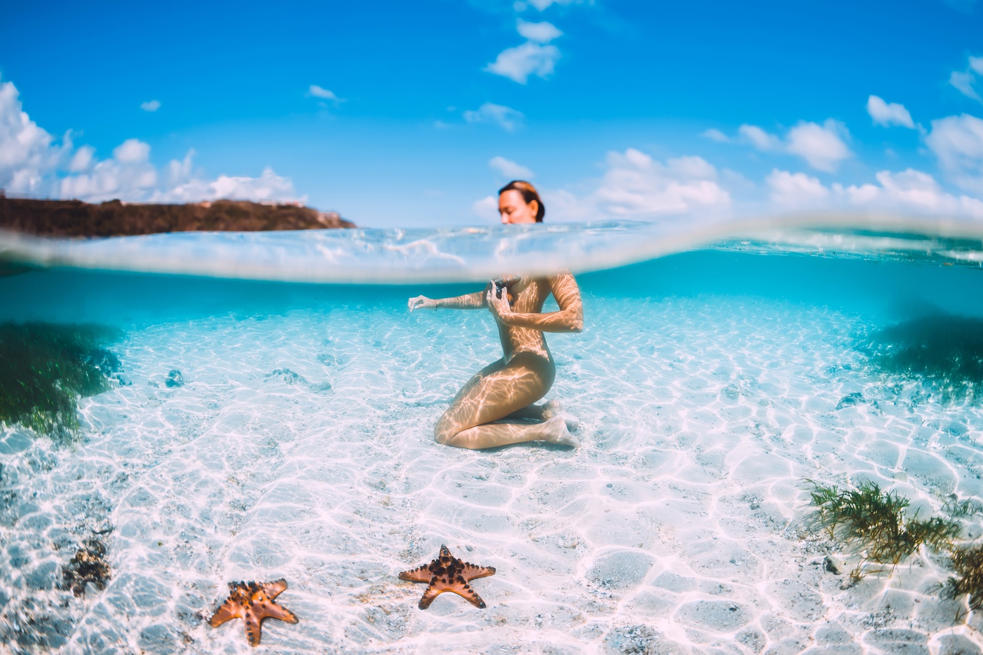 Naked woman swim in blue ocean with starfish, underwater in trop 1920x1280 sp FKK-Lifestyle
