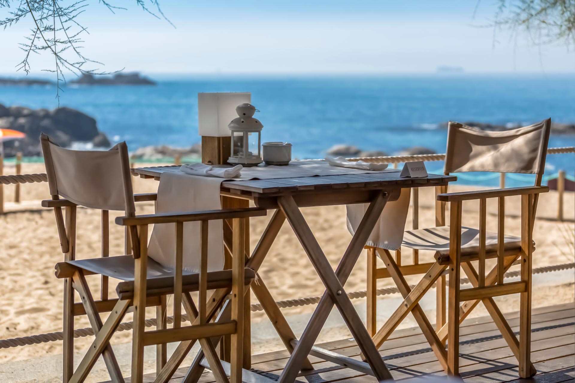 View of table and chairs in wood, with decorative elements and p FKK-Lifestyle