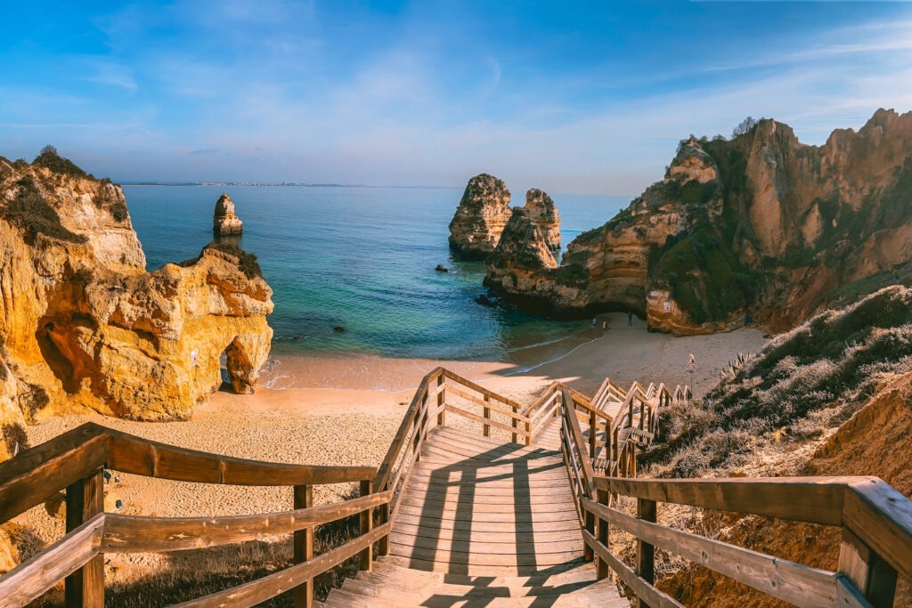 Goldener Sandstrand Praia do Camilo bei Lagos, Algarve – umgeben von imposanten Felsen und türkisblauem Wasser.