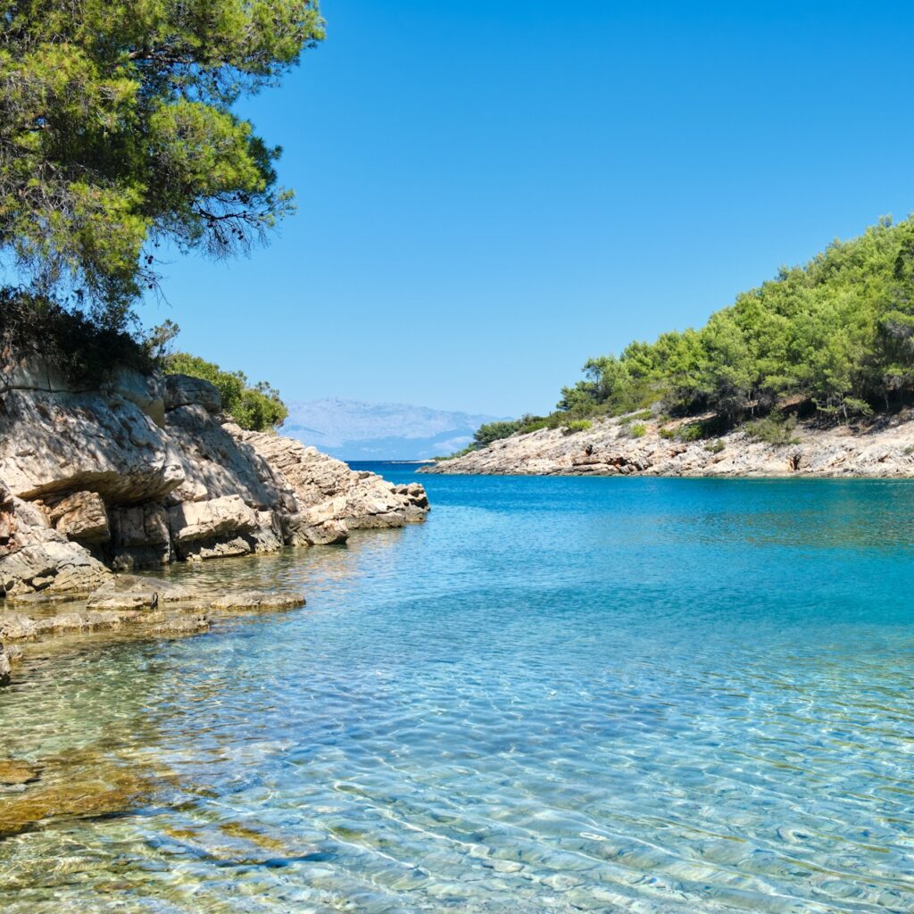FKK-Strand Vrboska – Naturparadies auf Hvar FKK-Strand Hvar bei Vrboska – glasklares Wasser, Felsen, Pinien und ruhige Naturbucht zum Entspannen.