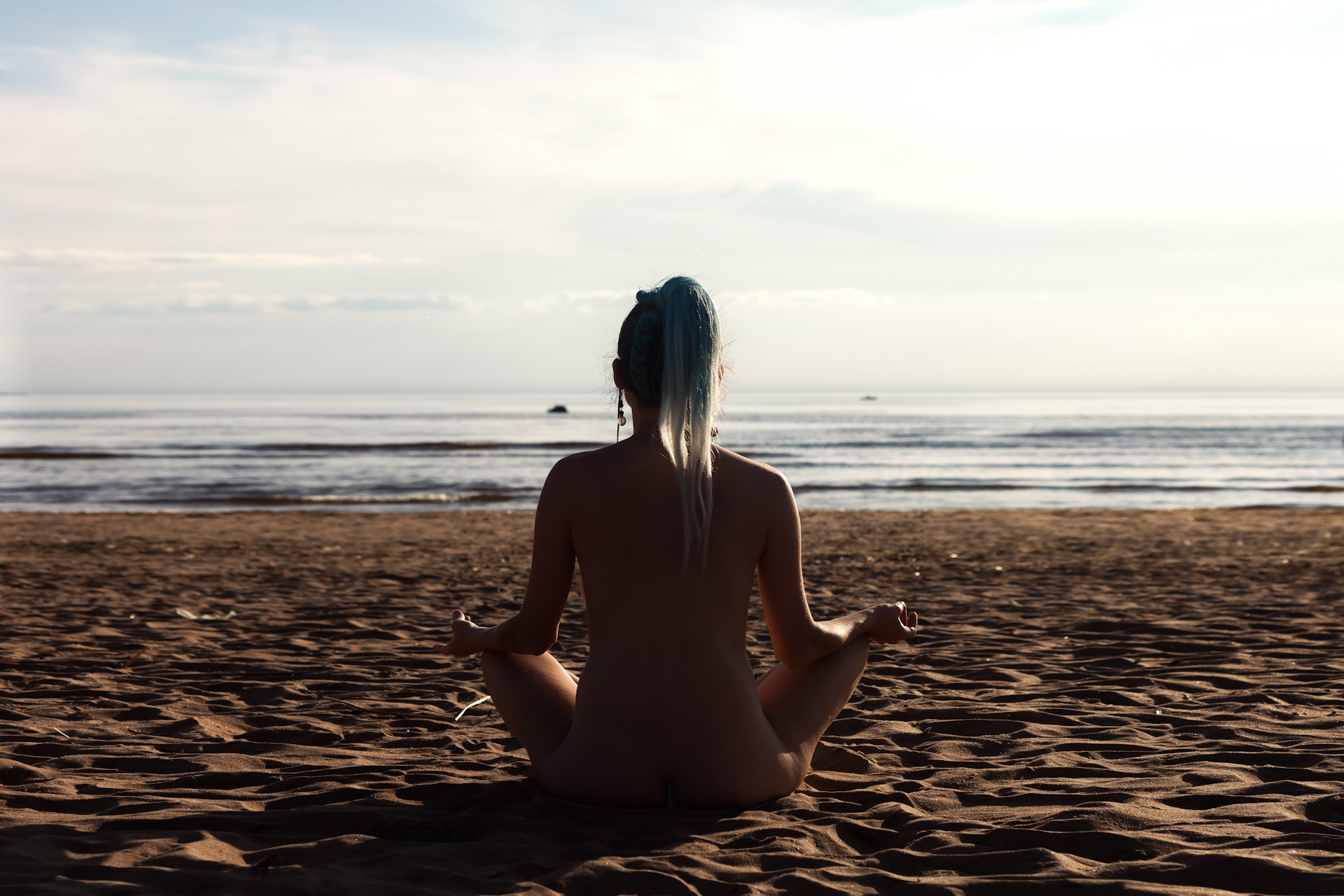 Rear view of silhouette of bare nudist lady sit asana yoga lotus FKK-Lifestyle