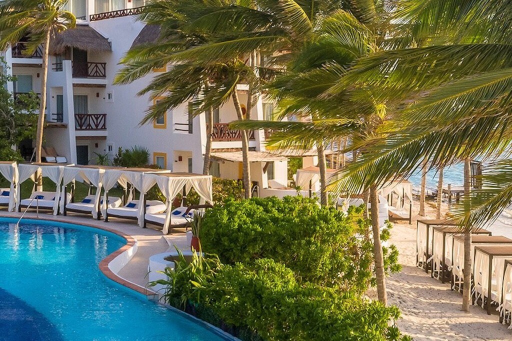 FKK Resort Desire Riviera Maya Pearl Mexiko Poolbereich mit eleganten Bali-Betten im Desire Riviera Maya Pearl Resort am Strand.