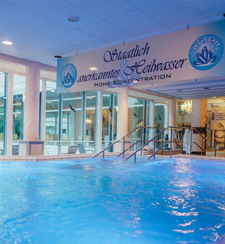 FKK-Resort Desire Riviera Maya mit Palmen, Gartenwegen und Strohdach-Pavillons in der Sonne.