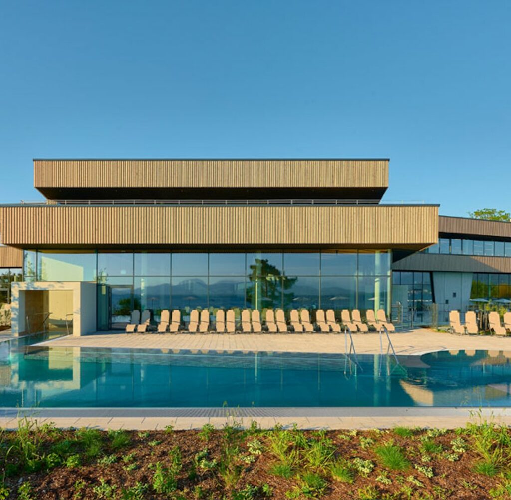 FKK-Resort Desire Riviera Maya mit Palmen, Gartenwegen und Strohdach-Pavillons in der Sonne.