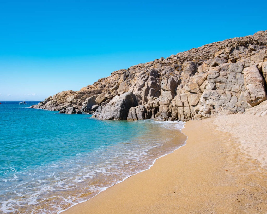 Agrari Beach – FKK-Paradies auf Mykonos mit Sandstrand, Felsen und klarem Wasser FKK-Strand Agrari Beach auf Mykonos mit feinem Sand, Felsen und türkisblauem Wasser