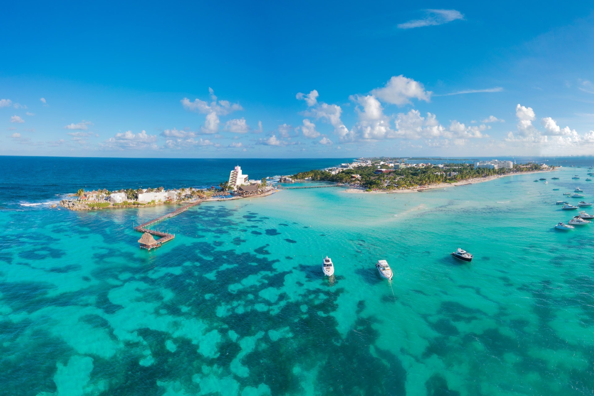 Katamaran-Tour nach Isla Mujeres mit Schnorcheln Luftaufnahme von Isla Mujeres mit türkisfarbenem Wasser und Booten – beliebtes Ziel für Katamaran-Touren und Schnorchelausflüge ab Cancún.