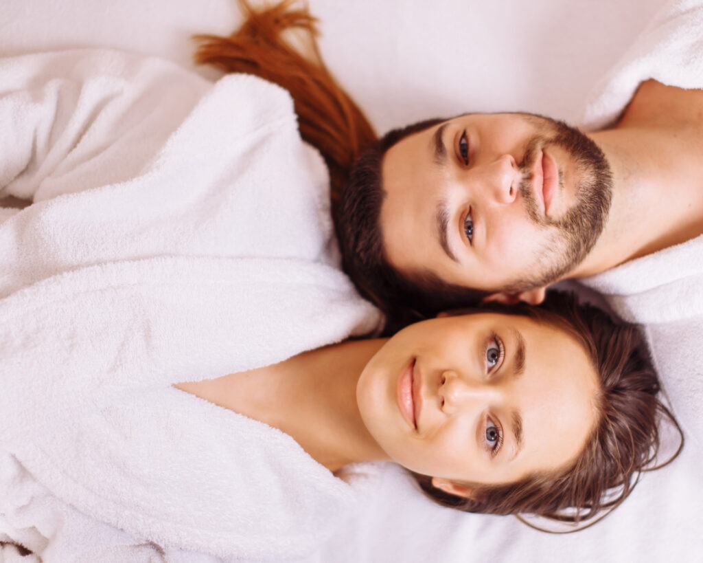 Paar genießt entspannt die Wärme in einer Sauna während eines Wellness- und FKK-Urlaubs in Österreich.