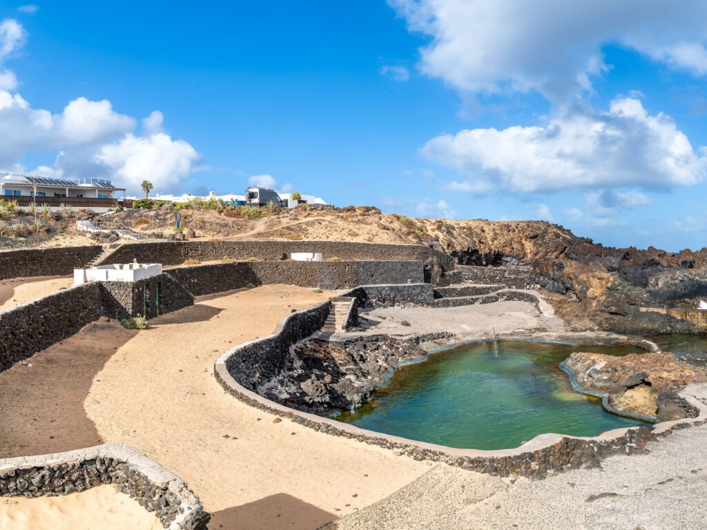 Discover Charco del Palo, unique coastal pools set amidst Lanzar FKK-Strand Playa de Maspalomas auf Gran Canaria mit goldgelbem Sand, DĂŒnen und Atlantikblick.