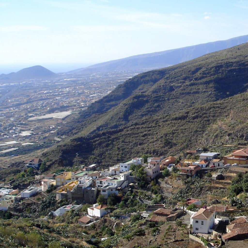 Zwei lächelnde Frauen liegen entspannt auf Handtüchern in einer Holzsauna im Warmbad Villach.