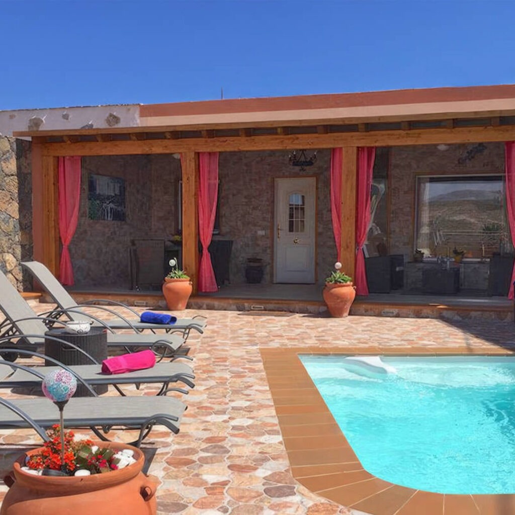 Zwei lächelnde Frauen liegen entspannt auf Handtüchern in einer Holzsauna im Warmbad Villach.