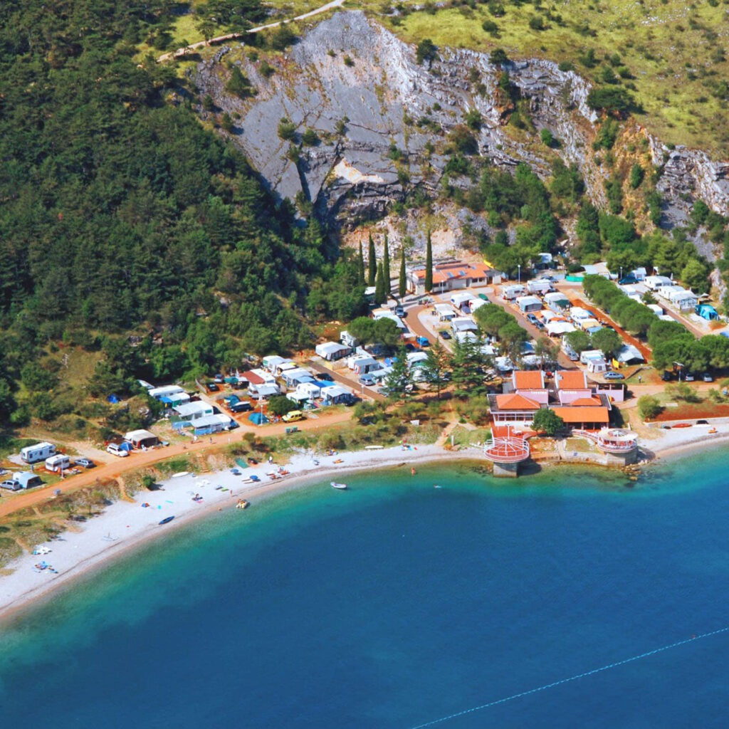 Zwei lächelnde Frauen liegen entspannt auf Handtüchern in einer Holzsauna im Warmbad Villach.