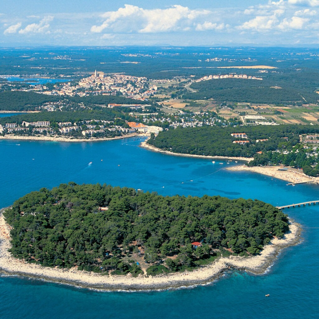 Zwei lächelnde Frauen liegen entspannt auf Handtüchern in einer Holzsauna im Warmbad Villach.