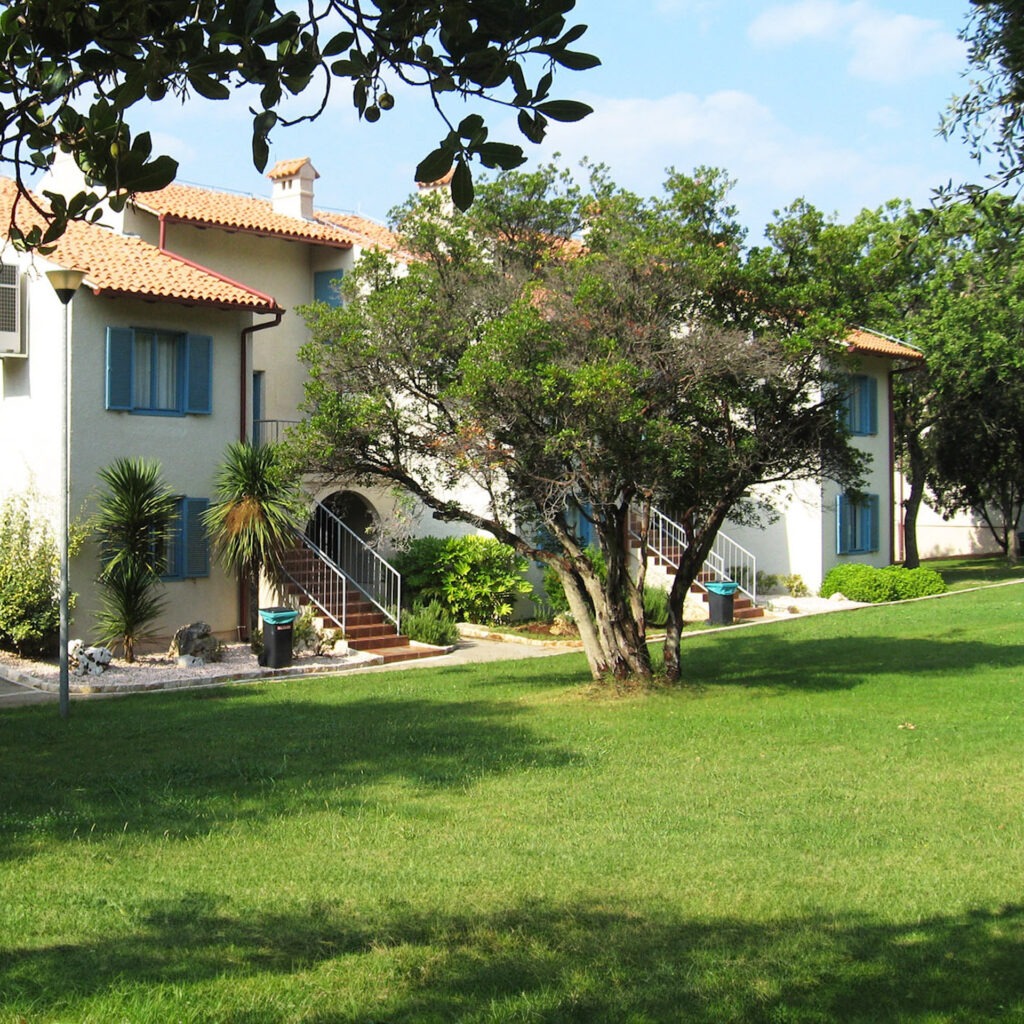 Zwei lächelnde Frauen liegen entspannt auf Handtüchern in einer Holzsauna im Warmbad Villach.