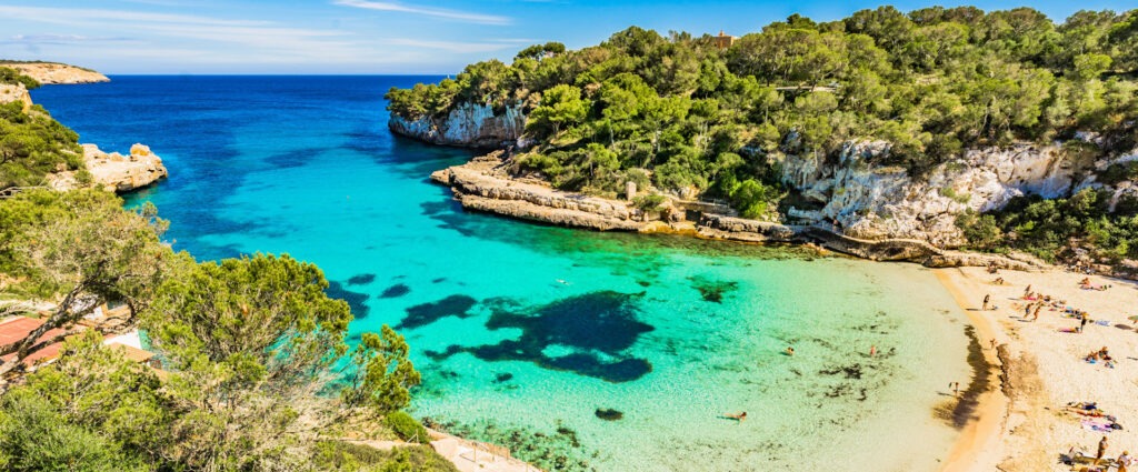 Junge Frau genießt nackt die Sonne am weißen Sandstrand eines tropischen Meeres – FKK-Urlaub, Freiheit und Entspannung pur