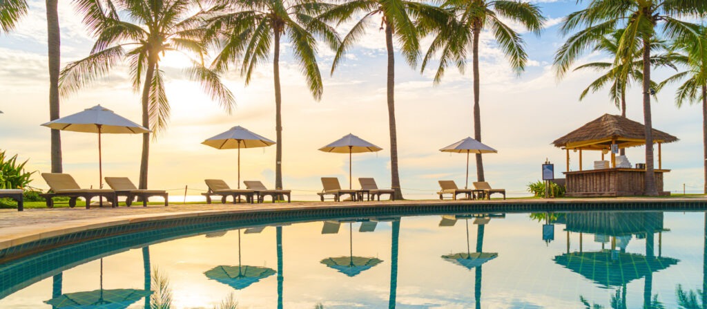 Junge Frau genießt nackt die Sonne am weißen Sandstrand eines tropischen Meeres – FKK-Urlaub, Freiheit und Entspannung pur