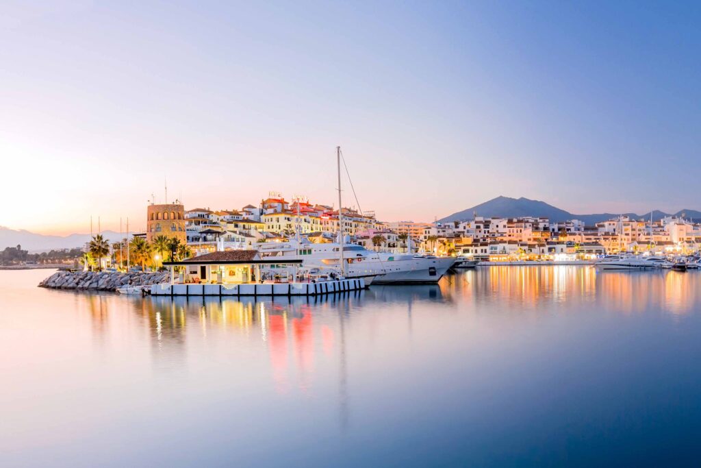 Yachthafen Costa del Sol bei Sonnenuntergang mit Stadt, Booten und Meer Spanien