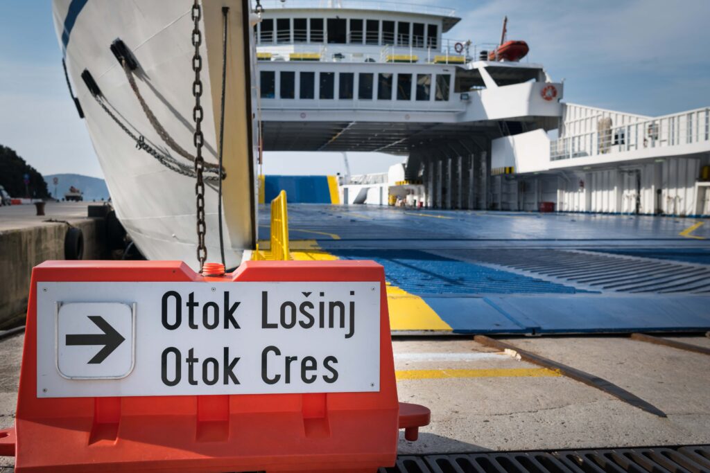 FKK-Urlaub auf der Insel Rab: Frau genießt nackt die Ruhe an einer felsigen Küste direkt am Meer