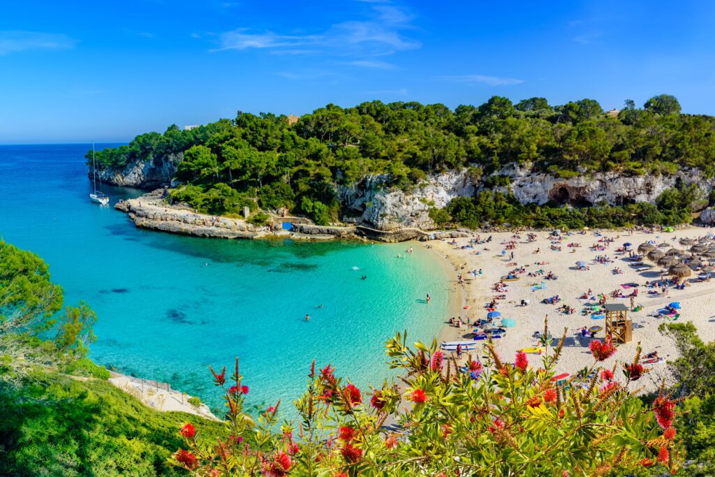 FKK Urlaub Balearen – idyllische Badebucht auf Mallorca mit türkisblauem Meer und Booten