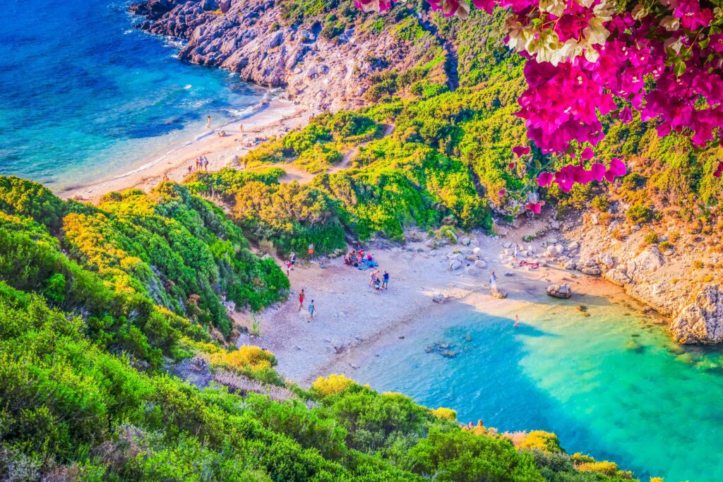 Blick auf die St. Paul’s Bay auf Rhodos mit Segelboot, türkisblauem Wasser und felsiger Küste