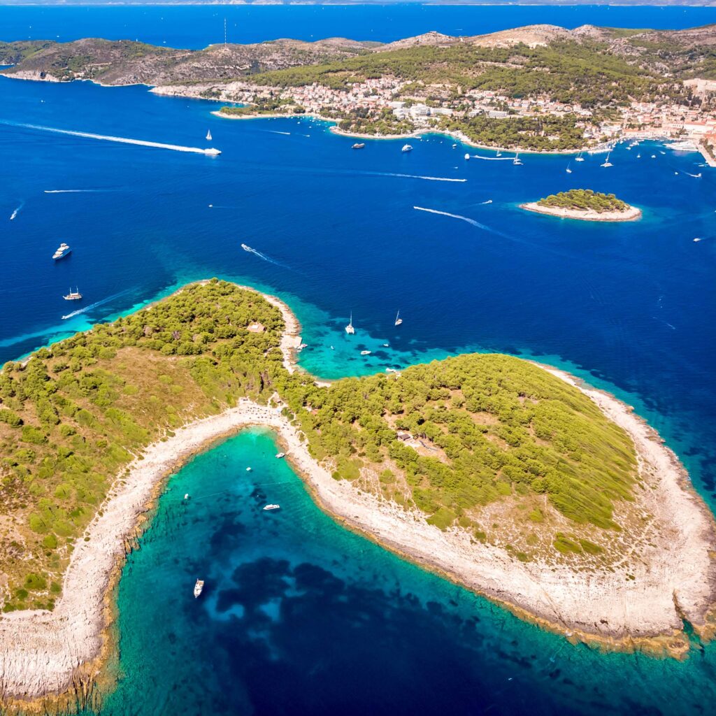 Aerial view of Paklinski Islands in Hvar, Croatia FKK-Strand Playa Mujeres auf Lanzarote mit goldenem Sand, türkisblauem Meer und weiter Küstenlandschaft