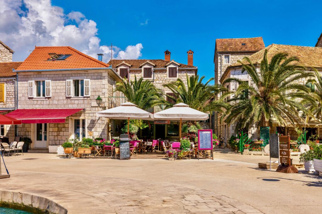 Blick auf die sonnige Küste von Lanzarote mit Palmen, Blumen und Meer – perfekte Kulisse für den FKK-Urlaub im Winter.