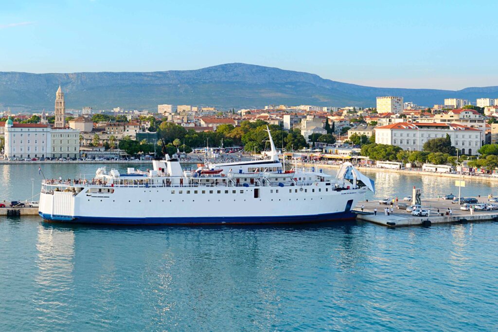 FKK-Urlaub auf der Insel Rab: Frau genießt nackt die Ruhe an einer felsigen Küste direkt am Meer