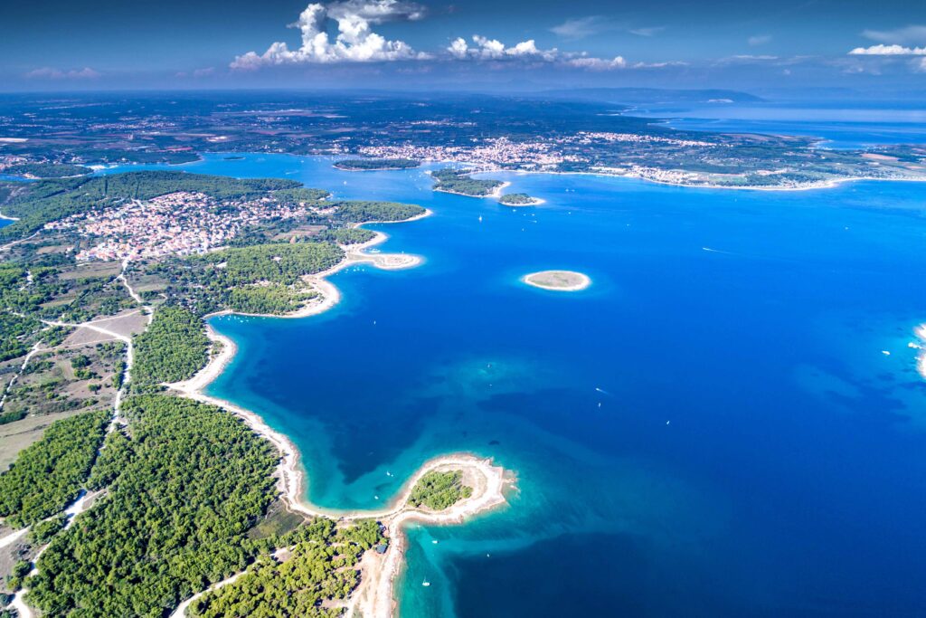 FKK-Urlaub auf der Insel Rab: Frau genießt nackt die Ruhe an einer felsigen Küste direkt am Meer