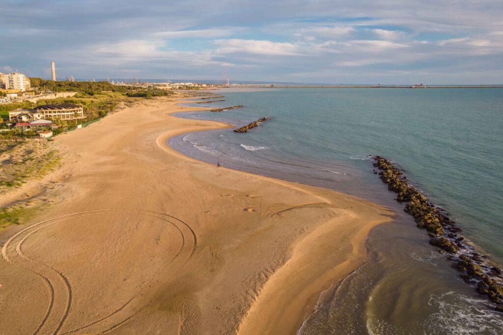 Aerial View of Mediterranean Sea at Sunset in Gela City, Caltani Luftaufnahme des Plage Naturiste de Cap d'Agde mit kilometerlangem Sandstrand, Yachthafen und Mittelmeerküste in Südfrankreich.