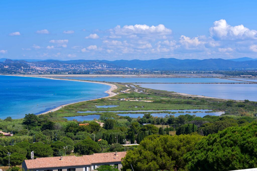 Scenic view of Giens peninsula on a sunny spring day with Medite Luftaufnahme des Plage Naturiste de Cap d'Agde mit kilometerlangem Sandstrand, Yachthafen und Mittelmeerküste in Südfrankreich.